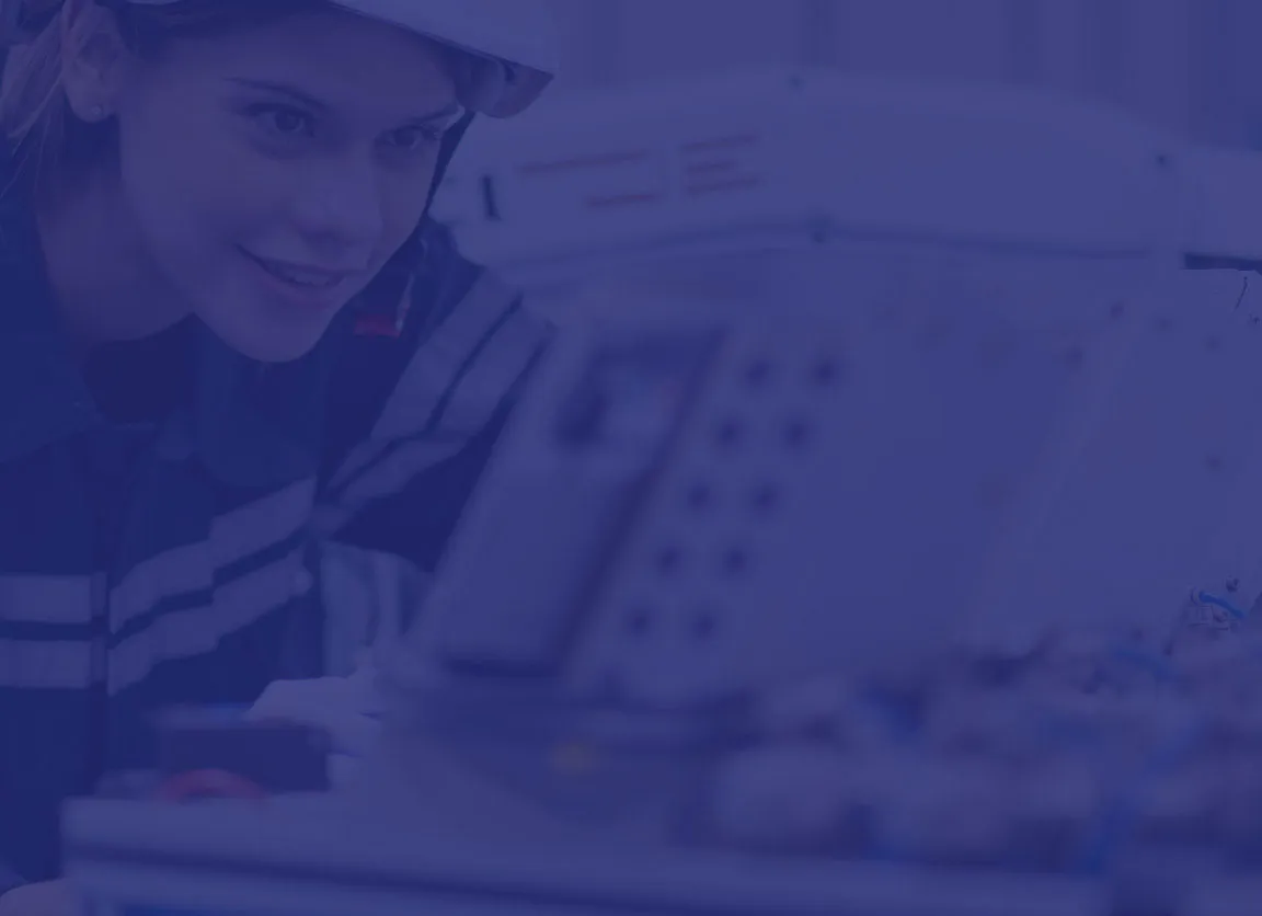 Woman wearing a hard hat inspecting machinery