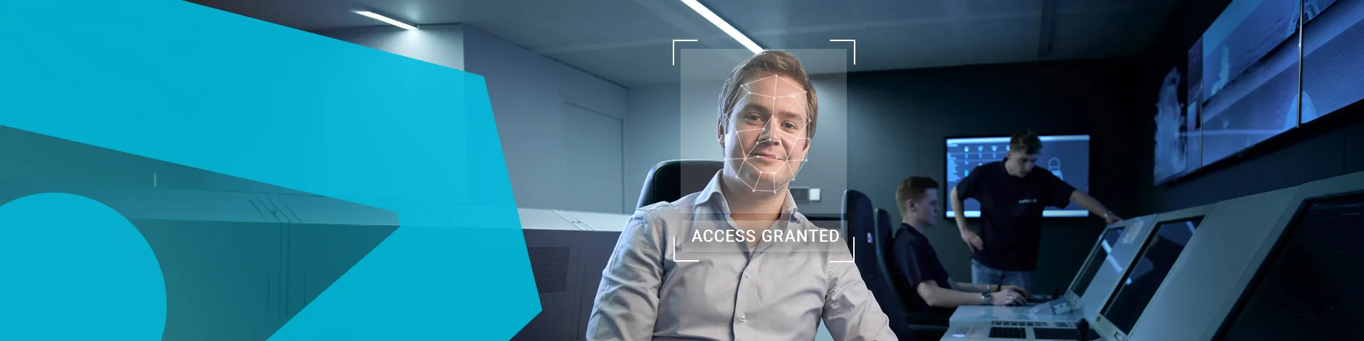 Man working at a bank of screens with biometric tech overlay on his face and the text 'access granted' below